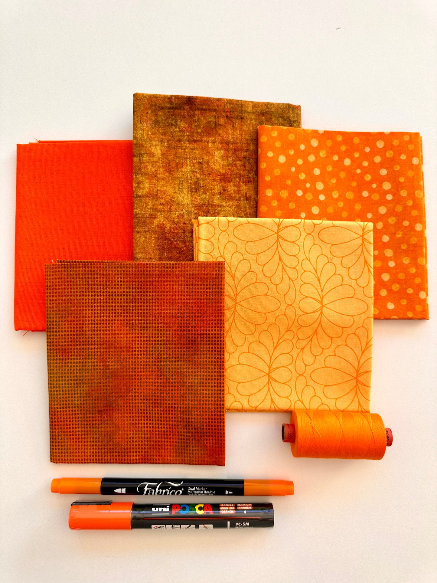 Orange rainbow stash builder bundles of quilting fabric in fat quarters with a Posca pen and Fabrico pen and rasant thread available at 2 sew textiles art quilt supplies