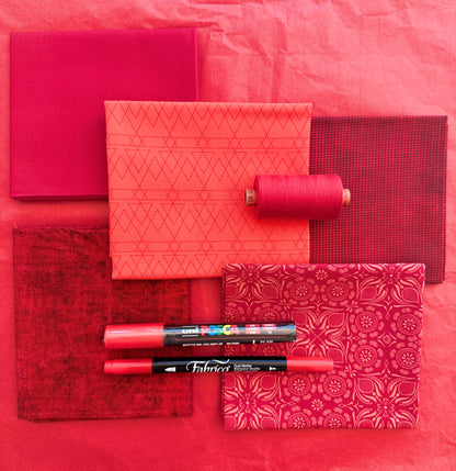 Red rainbow stash builder bundles of quilting fabric in fat quarters with a Posca pen and Fabrico pen. 