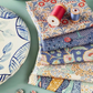 display image of blue fabrics with cotton reels and buttons - Tilda hometown precut collection 2 Sew Textiles Art Quilt Supplies